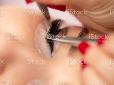 Close-up of Individual False Eyelash Application with Tweezers