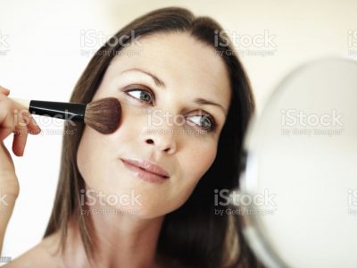 Closeup of pretty woman applying makeup