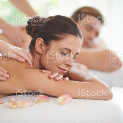 A husband and wife lying receiving massages at a spa