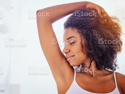 Shot of an attractive young woman smelling her armpits during her morning beauty routine